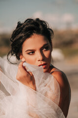 Close-up portrait of a brunette model girl in the role of a bride. Beautiful face, portrait at...