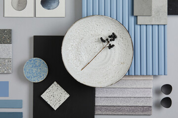 Flat lay composition of stylish architect moodboard with samples of textile, paint, blue wooden lamella panels and tiles. White, black, blue and light grey color palette. Copy space. Template.