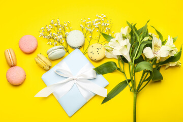 Composition with gift for International Women's Day celebration, macaroons and flowers on yellow background