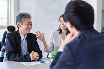 楽しい雰囲気でミーティングをするビジネスパーソン