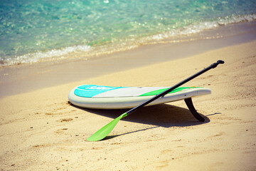 Sup Board on sandy beach in Maldives with writing 