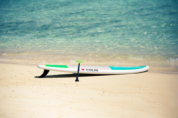 Fototapeta na wymiar Sup Board on sandy beach in Maldives with writing 