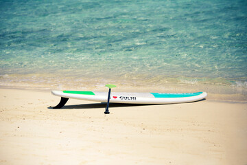 Sup Board on sandy beach in Maldives with writing 