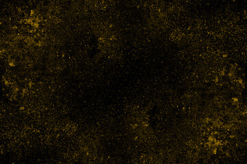 Scattered spread yellow dust particles on black background