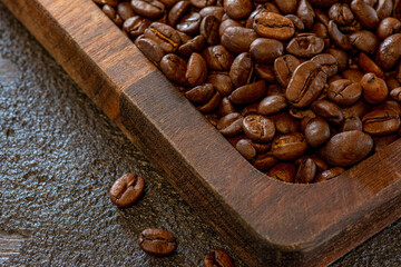 Beautiful large roasted beans of aromatic coffee on a wooden board. Soft selective focus.