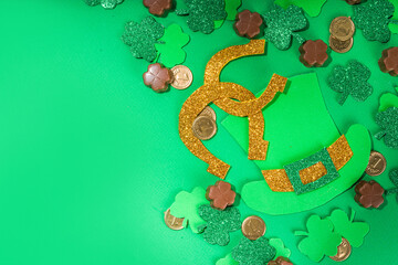 St Patrick flatlay background with shamrock clover leaves, leprechaun hat decor, golden coins and...