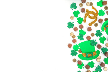 St Patrick flatlay background with shamrock clover leaves, leprechaun hat decor, golden coins and...