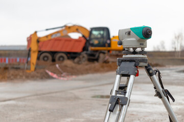 Level or total station at a construction site. Geodetic construction equipment during earthworks.