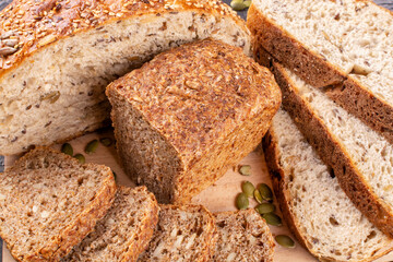 Slices and halves of round and square bread made of whole wheat flour with the addition of flax seeds, sesame seeds, pumpkin, sunflower. Bread without yeast, with sourdough. Proper nutrition.