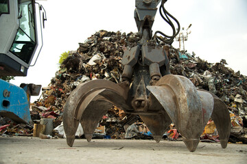 Large tracked excavator working a steel pile at a metal recycle yard. Industrial scrap metal...