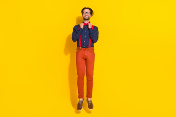 Full size photo of young man jump up correct bowtie party well-dressed isolated over yellow color background