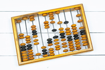 Old antique wooden abacus on white wooden background