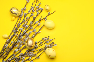 Painted Easter eggs and pussy willow branches on yellow background