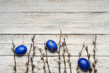 Painted Easter eggs and pussy willow branches on wooden background