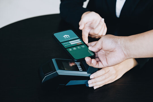 Payment security technology concept and service fees, Employees are holding electronic card machines for customers to use smartphone mobile to pay via paywave technology.
