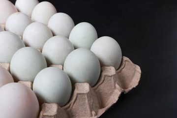 Close up of Eggs white in paper tray on black background