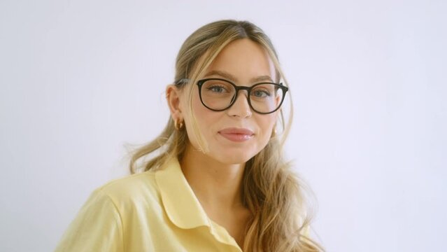 Portrait of happy smiling young attractive caucasian woman in eyeglasses looking on camera.	
