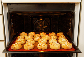 Homemade sweet buns with apple and lemon decorated with almond petals baked in the home oven. Shallow focus.