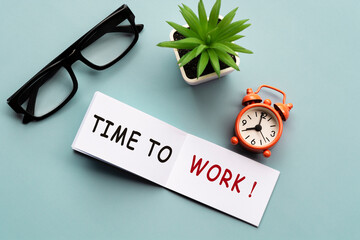 Time to work on notepad with alarm clock show eight o'clock morning time.