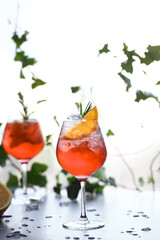 an aperol drink with ice is on the table on a sunny summer day