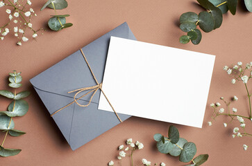 Save the date card mockup with envelope and eucalyptus and gypsophila twigs.