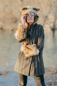Stylish woman in fur wear on lakeside