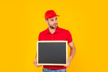 unshaven young man in red shirt hold blackboard with copy space on yellow background, announcement