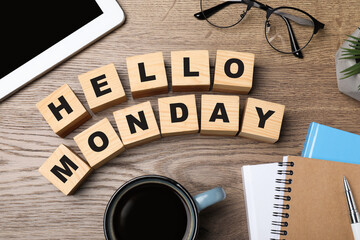 Cubes with message Hello Monday, office stationery and cup of coffee on wooden desk, flat lay