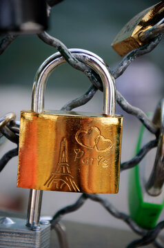 Love lock with Eiffel tower and hearts carving attached to bridge in golden sunset light. Paris, France. Romantic vacation concept