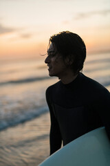 Fototapeta premium 朝の海でサーフィンをする男性