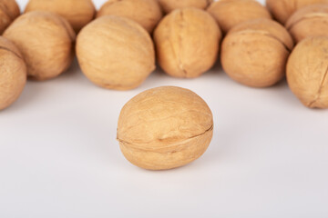 Many walnuts on a white background one nut lies separately
