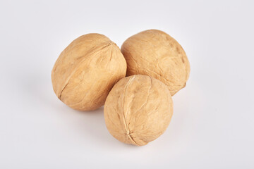 Three walnuts lie side by side on a white background