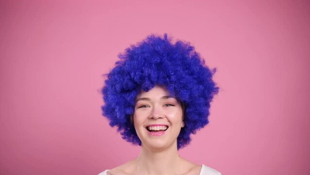 Close-up Portrait of Young Smiling Woman In blue Wig. Millennial female with blue curly hair.