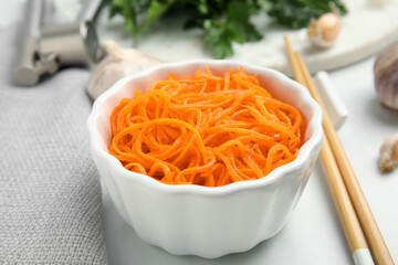 Delicious Korean carrot salad in bowl on white table