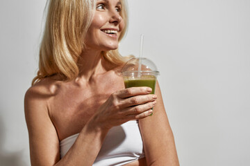 Partial image of woman drinking cocktail or juice
