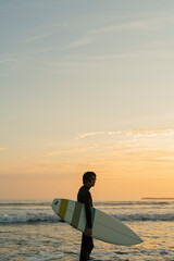 朝の海でサーフィンをする男性