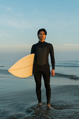 Fototapeta na wymiar 朝の海でサーフィンをする男性