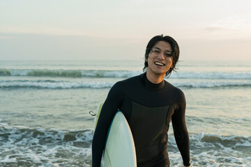 朝の海でサーフィンをする男性
