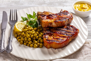 grilled pork t-bone steaks with boiled green peas