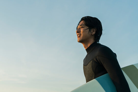 朝の海でサーフィンをする男性