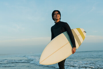 朝の海でサーフィンをする男性