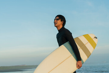 朝の海でサーフィンをする男性