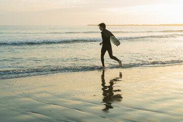 朝の海でサーフィンをする男性
