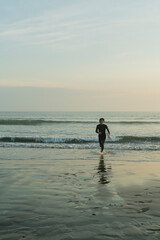 朝の海でサーフィンをする男性