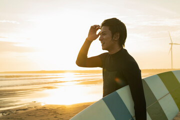 朝の海でサーフィンをする男性
