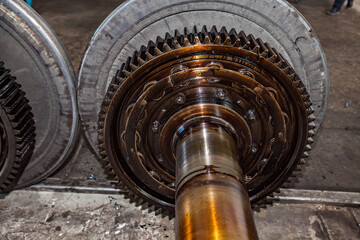 Close-up photo of Locomotive wheel with drive gear. Oily roll bearing. Train car and loco repair plant.
