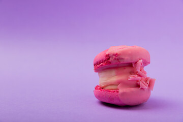 Fototapeta na wymiar Delicious berry macaroons on a lilac paper background. French meringue cookies macaron. Culinary and cooking concept. Copy space.