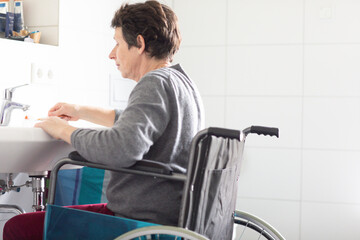 Ältere Frau im Rollstuhl in einem Badezimmer
