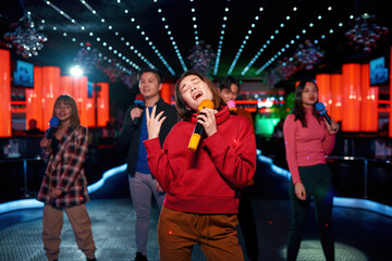 Asian band singing and dancing at karaoke party at night club
