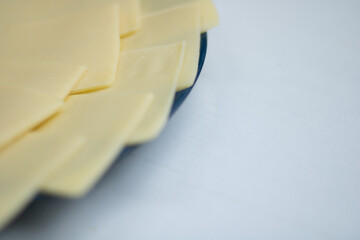 cheese thinly sliced ​​and laid out on a plate with copy space